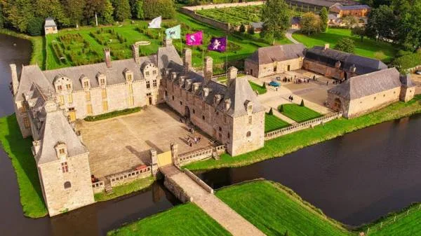 Image of the new wizarding school - Le Rocher Portail - seen from above. You can see the flags of the different houses as well as the gardens.